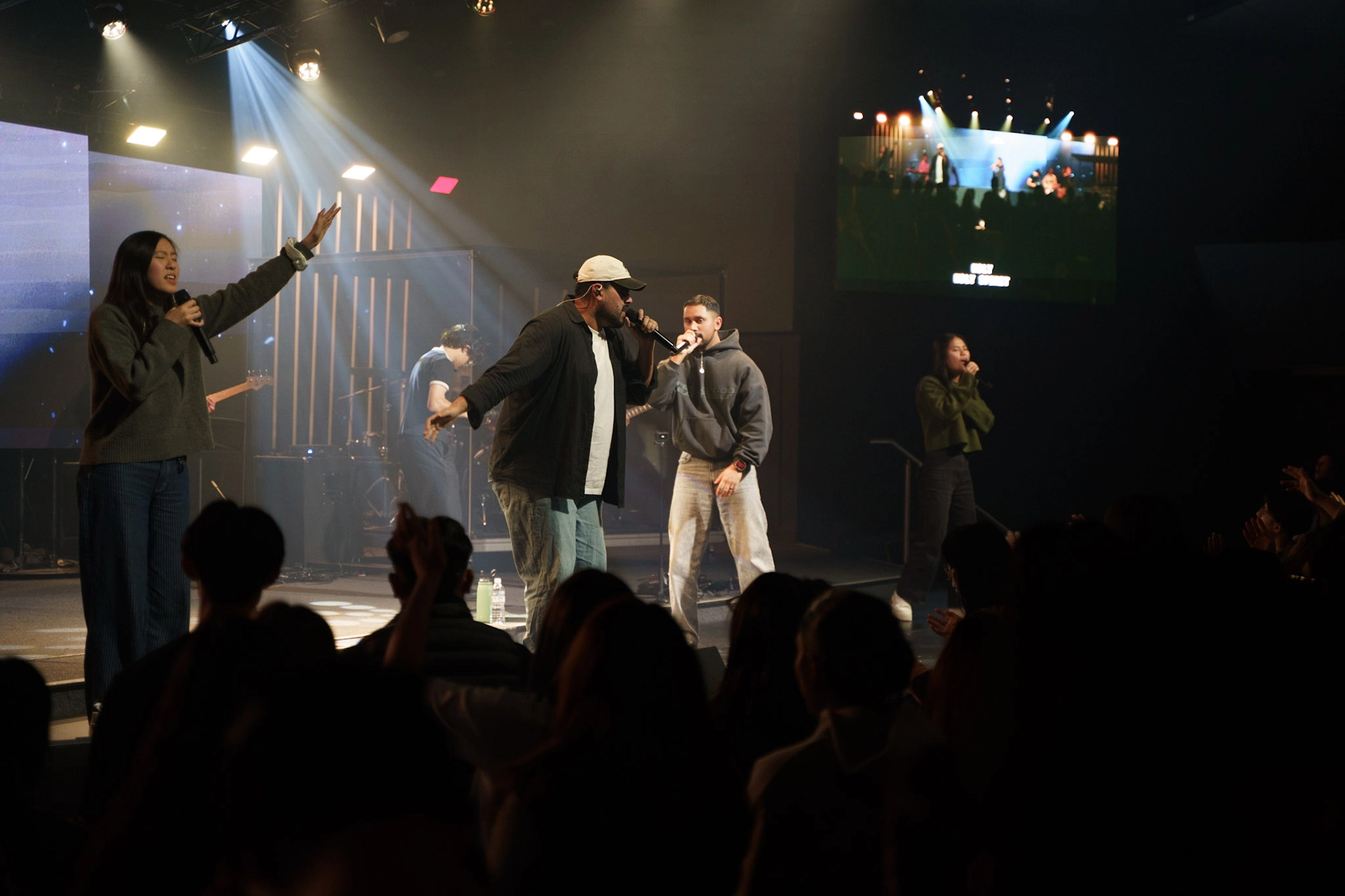 Young adults singing on stage during a worship night